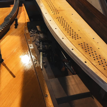 Remontage du cadre et des éléments mécaniques d’un piano acoustique après restauration