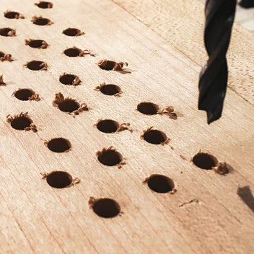 Travail de restauration sur la table d’harmonie d’un piano acoustique avec reprise des perçages et de la structure