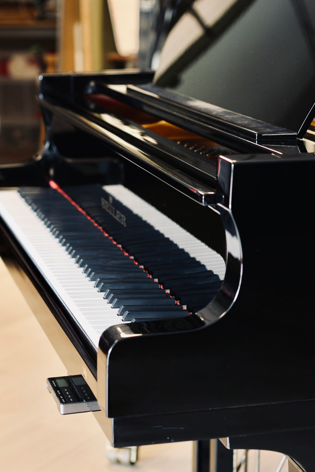 Vue de côté du Seiler 206 noir brillant, piano à queue d’occasion disponible chez Accord & Co